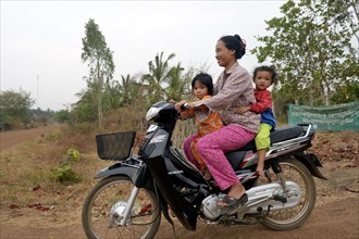 Woman with two young children on a motorcycle