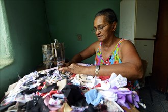 Woman manufacturing rag rugs in homework