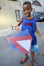 Young boy holding a kite in a slum or favela