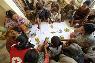 Villagers participating in hygiene training run by a charity organisation using illustrations to display causes and consequences of poor hygiene