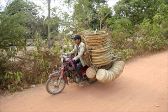Man transporting baskets by motorbike to the market