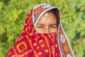 Veiled Ahir woman in traditional colorful with headgear