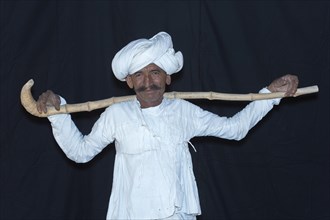 Rabari Man wearing a white clothes with turban and holding walking stick