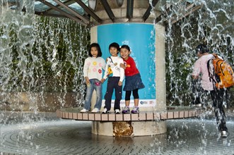 Children standing on a fountain