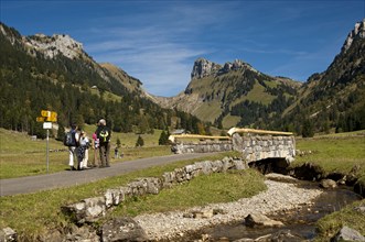 Hikers at Groenbach stream in front of the summit of Schibe Mountain