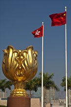 Sculpture of a gilded eternal Bauhinia flower with the flags of Hong Kong and China