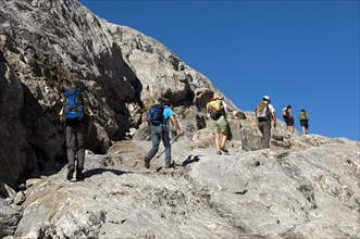 Hikers crossing the exposed bedrock of Tsanfleuron Glacier