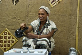 Ethiopian woman pours coffee in a traditional coffee ceremony