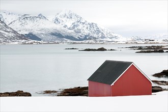 Wintery fjord landscape with a red boathouse