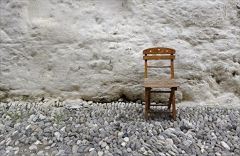 Old folding chair in front of a wall