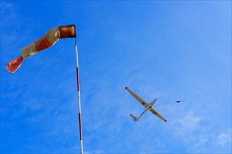 Windsock and a glider during a winch launch against the wind