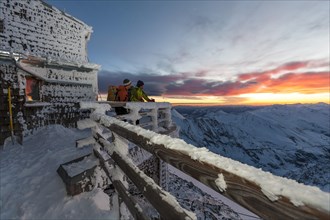 Two mountaineers watching the sunrise at the Archduke Johann cabin on Mt Grossglockner