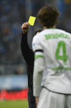 Referee Peter SIPPEL showing a yellow card to Roel BROUWERS of Borussia Moenchengladbach for committing a foul