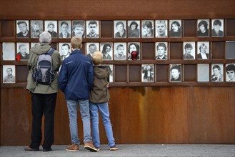 Visitors in front of photos of victims of the Berlin Wall