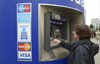 Woman operating an EC-ATM for VISA