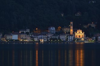 Village of Porto Ceresio with the Parish Church of Chiesa Sancto Ambrosio on Lake Lugano or Lago di Lugano at night