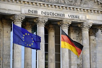 Flags of the European Union and Germany in front of the main gable of the Reichstag Building