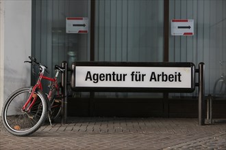 Bicycles parked beside the sign 'Agentur fuer Arbeit'