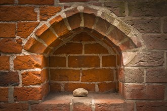 Stone in the niche of a brick wall