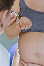 Pregnant woman recieving homeopathic medicine from her midwife during delivery