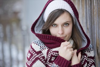 Young woman wearing a knitted sweater with a hood