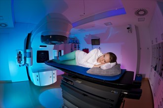Patient lying in a linear particle accelerator for radiation treatment of the foot