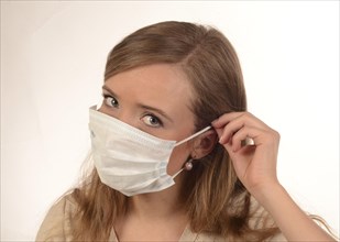 Young woman puts on a face-mask