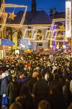 Crowds thronging between stores and Christmas market stalls