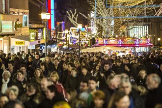 Crowds thronging between stores and Christmas market stalls