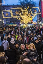 Crowds thronging between stores and Christmas market stalls