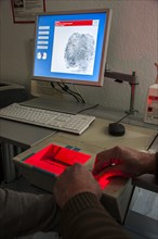 Fingerprints and palm prints of a suspicious person are recorded with a scanner
