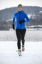 Female jogger on a run in winter at Lake Baldeney