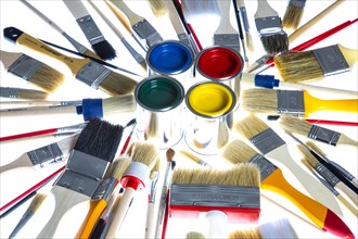 Different types of brushes and cans of paint