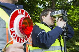 Police during speed monitoring with a laser gun or hand-held laser meter