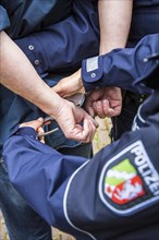 Police officer putting handcuffs on an offender