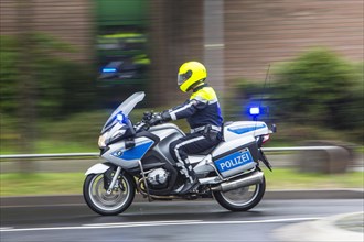 Policeman wearing yellow a helmet on a motorcycle