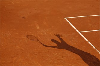 Shadow of a tennis player serving the ball
