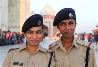 Two security guards in uniform in front of the Taj Mahal