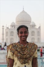 Young Indian woman in a sari in front of the Taj Mahal