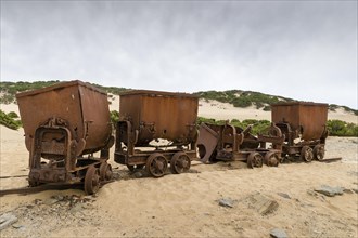 Tippers or tipping wagons on old mine tracks in the dunes