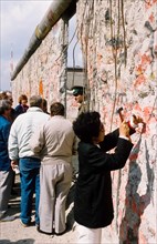 Wall-peckers' hammering away at the Berlin Wall