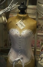Torso of a shop-window mannequin wearing a garter bustier in a shop window