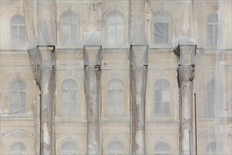 Facade of a historic building shrouded with tarpaulins during renovation