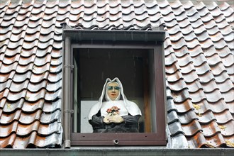 Caricature of a nun in a window