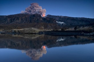 Eruption of Eyjafjallajoekull volcano with its reflection