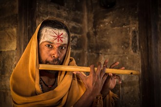 A sadhu playing a flute