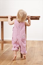 Toddler standing at a wooden table