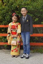 A Japanese girl wearing a kimono and a Japanese girl wearing western clothing