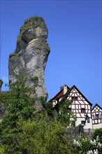 Half-timbered house next to towering karst rocks