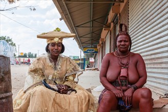 Herero woman and Himba woman woman in traditional dress sitting next to each other